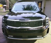 kia-telluride-with-black-overlay-over-new-emblem-grille.webp
